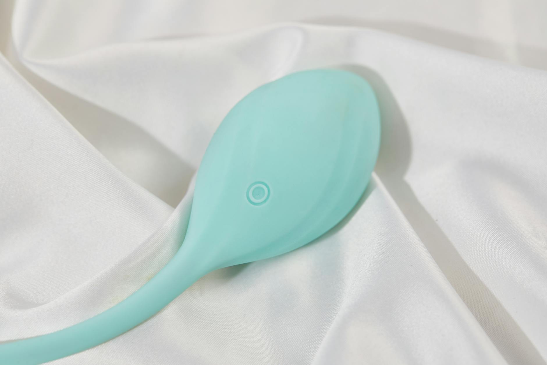 Person holding blue and pink silicone vibrators in contemplative hands, representing gentle pleasure options
