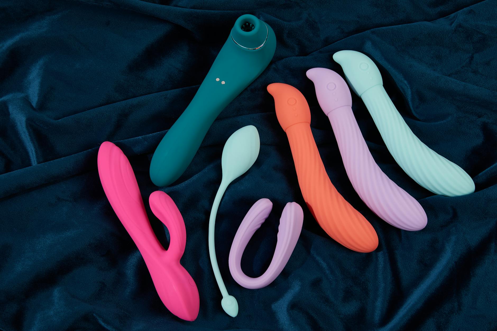 A young couple standing together, holding a blue vibrator, symbolizing modern intimacy and shared pleasure