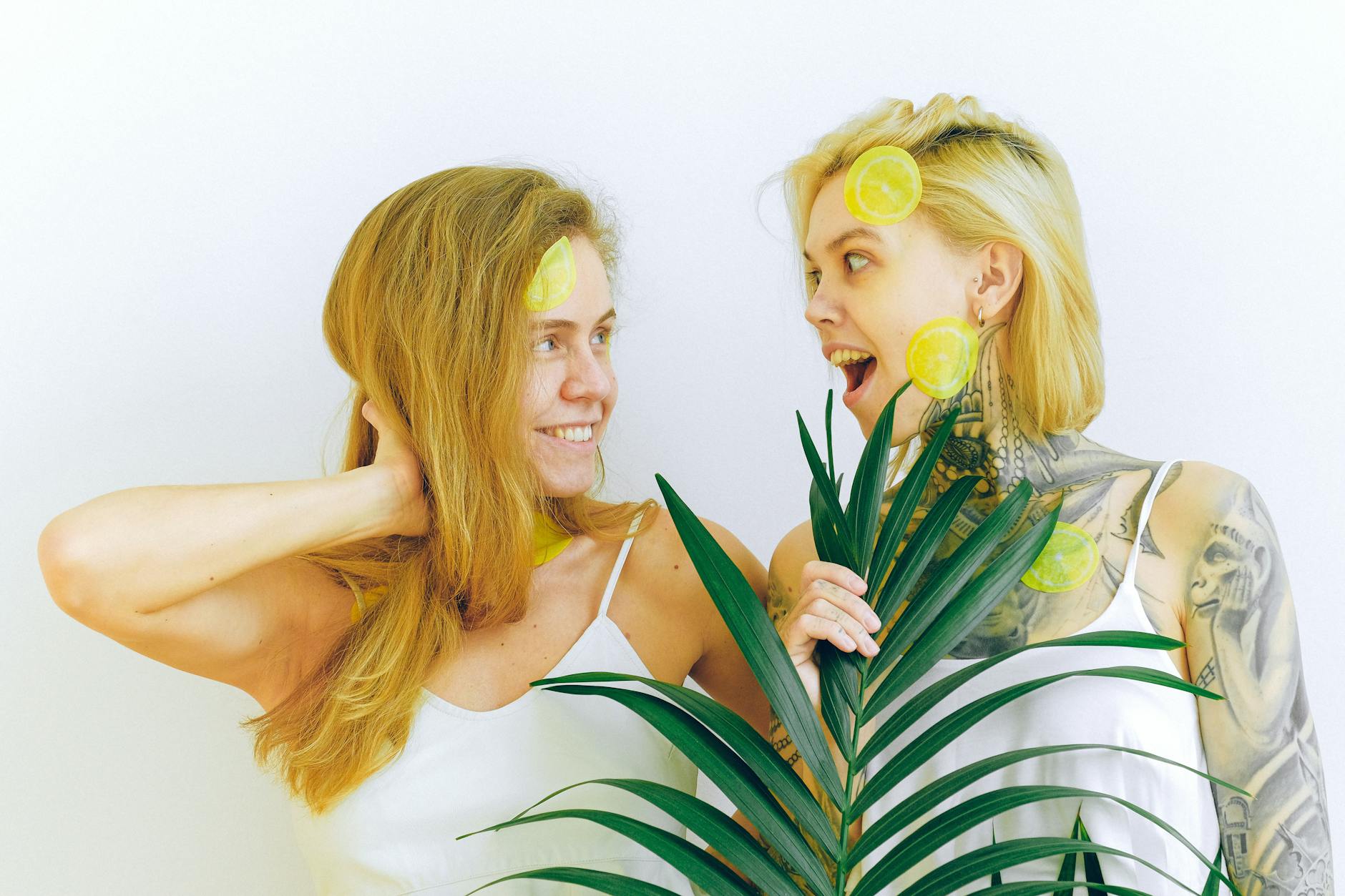 Two women laughing together with lemon slices, expressing joy and comfort during recovery
